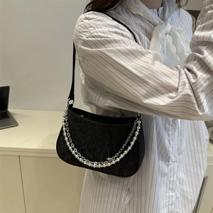 Chic black underarm bag with vintage texture, pearl chain and star pendant on model