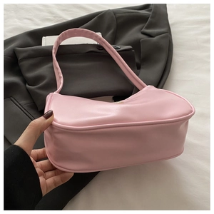 Detailed view of the soft pale pink faux leather shoulder bag on a grey blazer