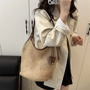 Große beige geflochtene Strandtasche aus Stroh mit braunen Lederriemen für den Sommer