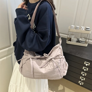 Large pale purple nylon tote bag with bow details shown on model for casual commuting