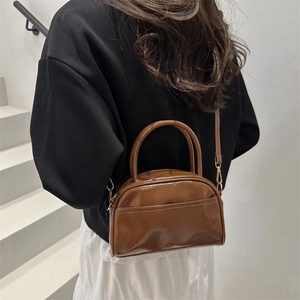 Minimalist brown glossy leather Boston bag with top handles and adjustable strap