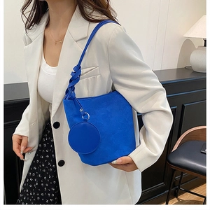 Détail du sac seau hobo en daim bleu avec bandoulière nouée et mini porte-monnaie