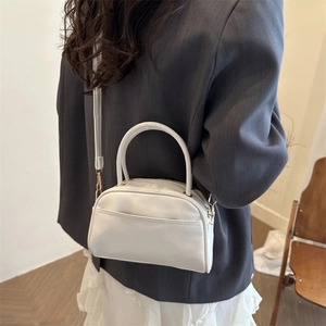 Chic white PU leather handbag and crossbody bag worn with a stylish blazer
