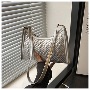 Detail of silver baguette bag featuring quilted diamond pattern and a slim shoulder strap