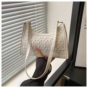 Detail shot of white quilted shoulder bag with classic lattice pattern and PU leather