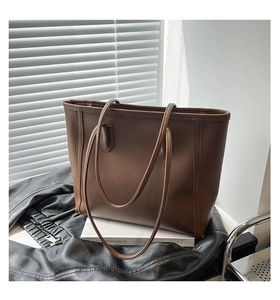 Detail of vintage dark brown tote bag with matte leather finish and vertical stitching detail