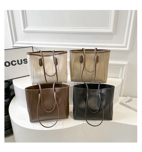 Detailed display of vintage tote bags in four neutral colors on a minimalist display stand