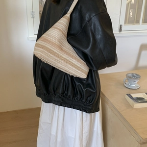 Sac à bandoulière en paille tressée à rayures avec pieds en métal sur modèle