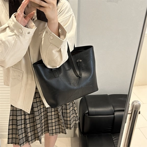 Minimalist black matte leather tote bag with slim shoulder straps for daily commuting