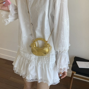 Minimalist gold shell-shaped acrylic clutch with metallic chain and embossed lines