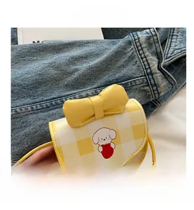 Detail of yellow checkered crossbody bag with cute dog print and leather bow accent