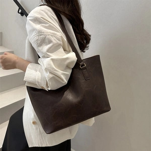 Chic dark brown faux leather tote bag for women shown as stylish shoulder bag on model