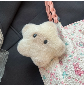 Détail d'un joli porte-clés en peluche en forme d'étoile sur un sac à bandoulière fleuri