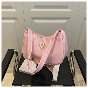 Close-up of pink PU leather handbag featuring a crystal heart buckle and bow detail