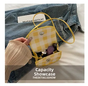 Detail view of mini yellow checkered crossbody bag showing interior storage capacity