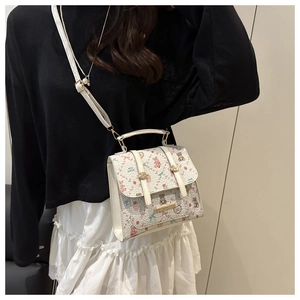 Detail of cute beige floral backpack with bear prints worn by a model in a casual outfit