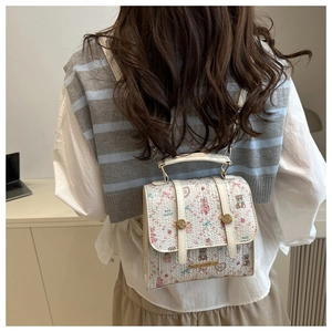 Floral bear print white leather mini backpack shown on model with shoulder straps