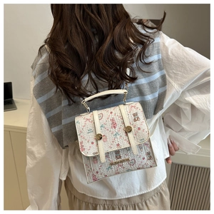 Close-up of cute beige school-style backpack with floral bear prints and metal studs