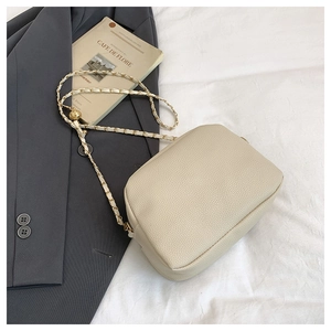 Detail of cream quilted leather crossbody bag with elegant gold chain and leather strap