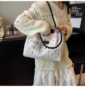 Detail of floral canvas tote with braided handle and white star plush pendant charm