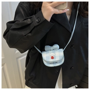 Close-up of a blue plaid mini crossbody bag featuring a 3D bow and cartoon dog pattern