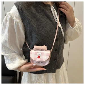 Close-up of pink checkered mini crossbody bag with cartoon cat and bow on model