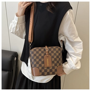 Détail du sac seau vintage avec motif à carreaux et bandoulière en tissu imprimé