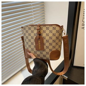 Detail of vintage beige bucket bag with brown leather trim and fashion strap