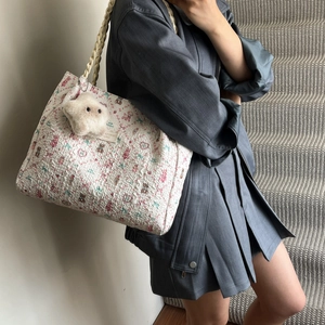 White quilted tote bag with floral bear prints and plush star charm on model