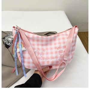 Detail of pink plaid canvas crossbody bag with teddy bear embroidery and rainbow charm