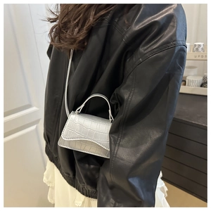 Détail du petit sac bandoulière argenté avec texture effet crocodile gaufré