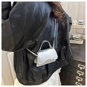 Détail du mini sac argenté avec texture crocodile, poignée et fine bandoulière