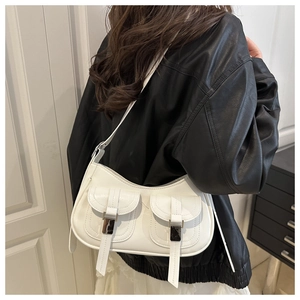 Detail of white PU leather baguette bag with dual front pockets and silver buckle closure