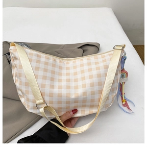 Detail of checkered crescent bag with adjustable strap and colorful rainbow charm
