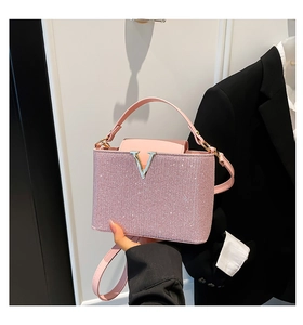 Detailaufnahme einer rosa Pailletten-Umhängetasche mit goldener V-förmiger Metallschnalle