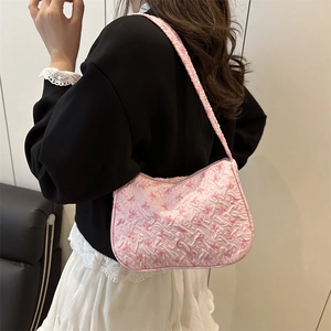 Pink floral pleated shoulder bag with bow patterns worn by a model in a stylish look