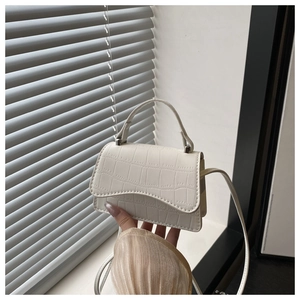 Détail d'un mini sac à bandoulière blanc avec texture crocodile et bandoulière épurée