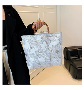 Detailed view of the silver-blue floral jacquard fabric and natural bamboo U-handle