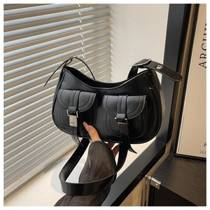 Close-up of black retro half-moon shoulder bag with double pockets and silver buckles
