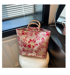 Detailed close-up of floral jacquard embroidery and natural bamboo handle on a bucket bag