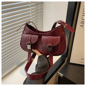 Detail of dark red underarm bag with double front pockets and silver hardware buckles