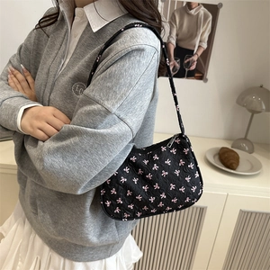 Black large floral shoulder bag with pink bows for women in a cozy home setting