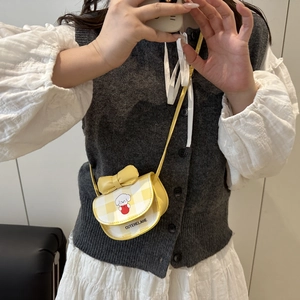 Mini yellow plaid crossbody bag with bow and cartoon dog print worn on a grey vest