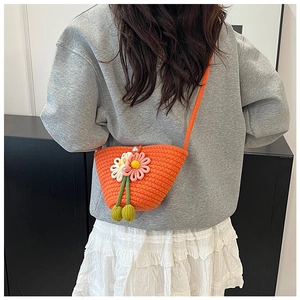 Detail einer orangefarbenen Häkeltasche mit handgefertigten rosa Blumendekoren