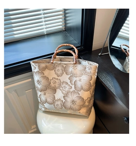 Detail of floral jacquard tote bag featuring retro bamboo handles and creamy base tone