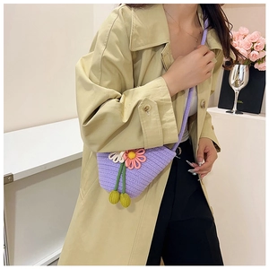 Details der lila gewebten Baumwolltasche mit floralem Häkeldesign und grünen Quasten