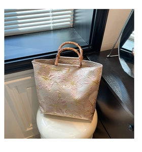 Detailed view of pink floral jacquard fabric with natural polished bamboo handle