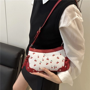 Sac à bandoulière blanc avec imprimé cerises, finitions en cuir rouge et rivets argent