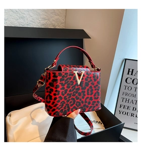 Detail view of red leopard print crossbody bag with elegant gold V-shape metal buckle