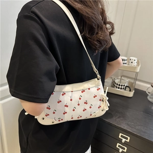 White cherry print underarm bag with drawstring bow detail and sleek shoulder straps